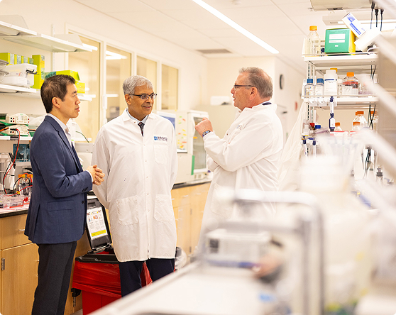 Two scientists and one executive in conversation in a lab