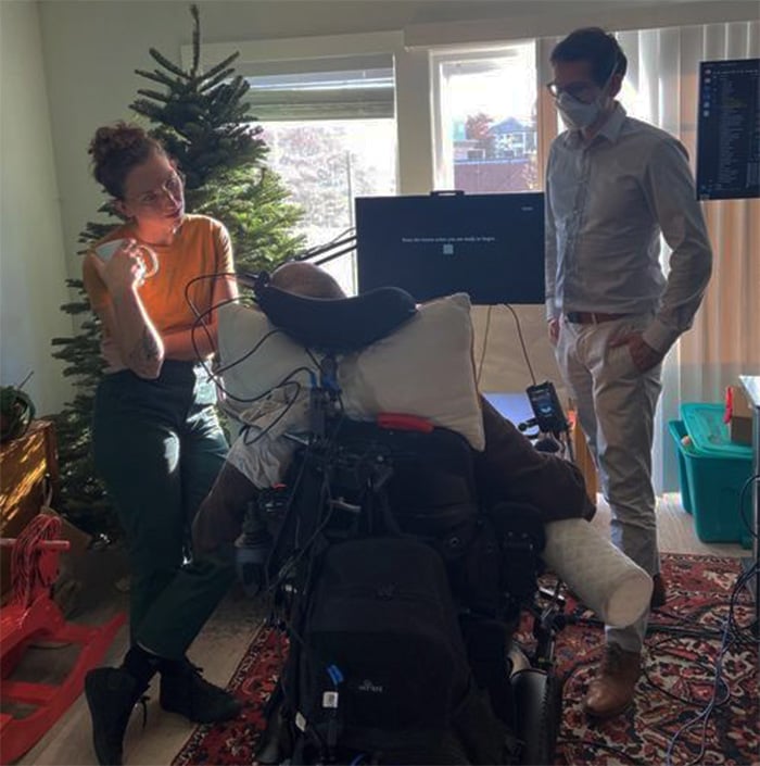 Photo of man in wheelchair in front of screen spelling out words.