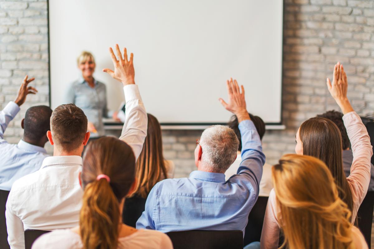 People raising their hands in a classroom