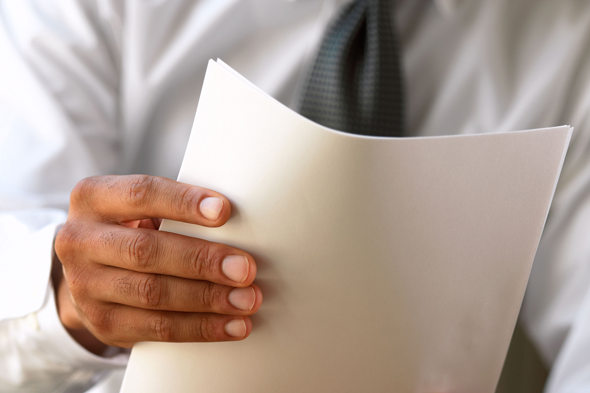 Close-up of a business man holding a stack of papers
