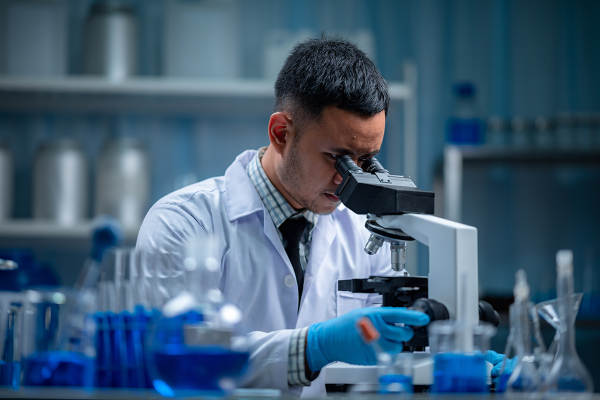 Scientist looking through a microscope in a laboratory.