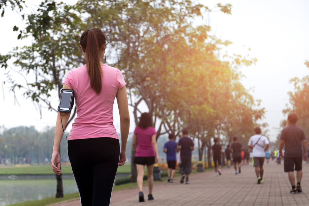 Group of people exercise-walking in a park.