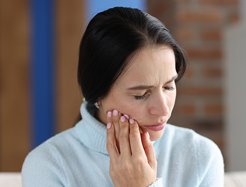 A woman experiences jaw pain.