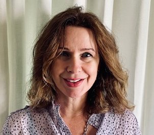 A woman with brown hair, smiling