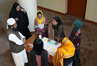 Seven people gathered around a table, having a meeting