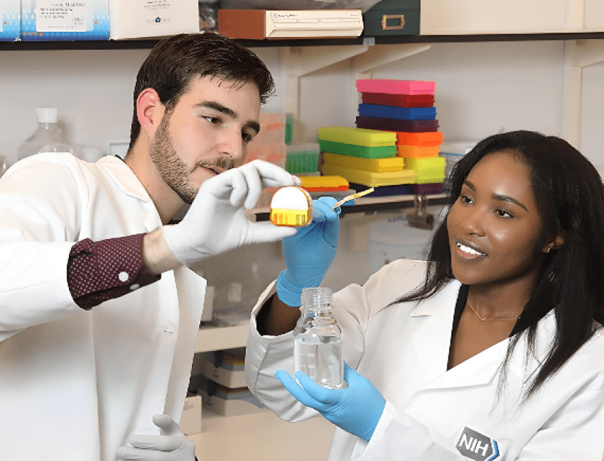 Two scientists smiling and conducting an experiment 