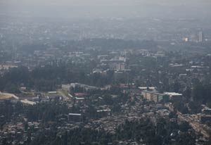 View of a city from far away and high up on a mountain, air is hazy, showing pollution