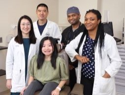 Clinical trial participant MinFen Lydia Foreman (seated) posed with members of NIDCR’s clinical team (from left to right), physician assistant Rachelle Chung, Drs. Ling Ye and Ayodeji Awopegba, and research nurse Danielle Elangue, at a recent visit.