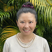 Headshot of Dr. Courtney Choy smiling with a flower in her hair