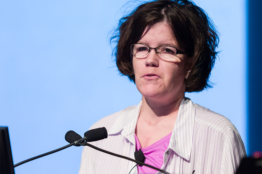 Erica Thiel speaking at a lectern..
