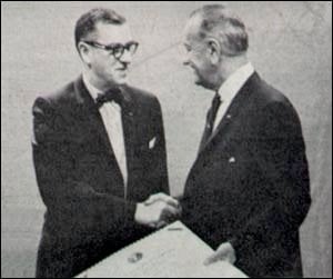 Black and white photo of two men in suits shaking hands