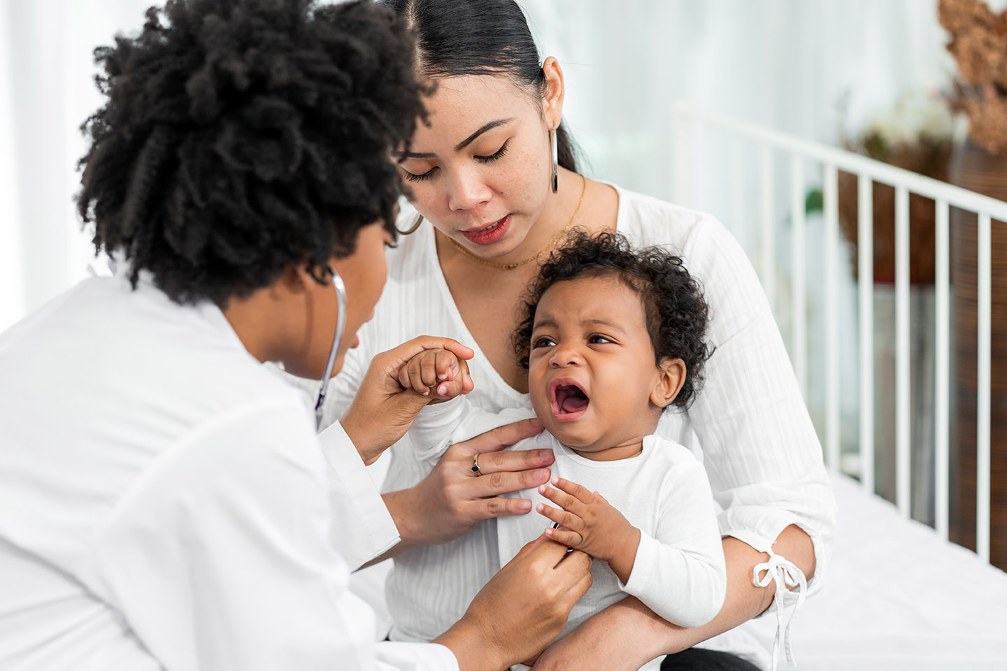 African american female pediatrician hold stethoscope to examine small child, accompanied by his mother