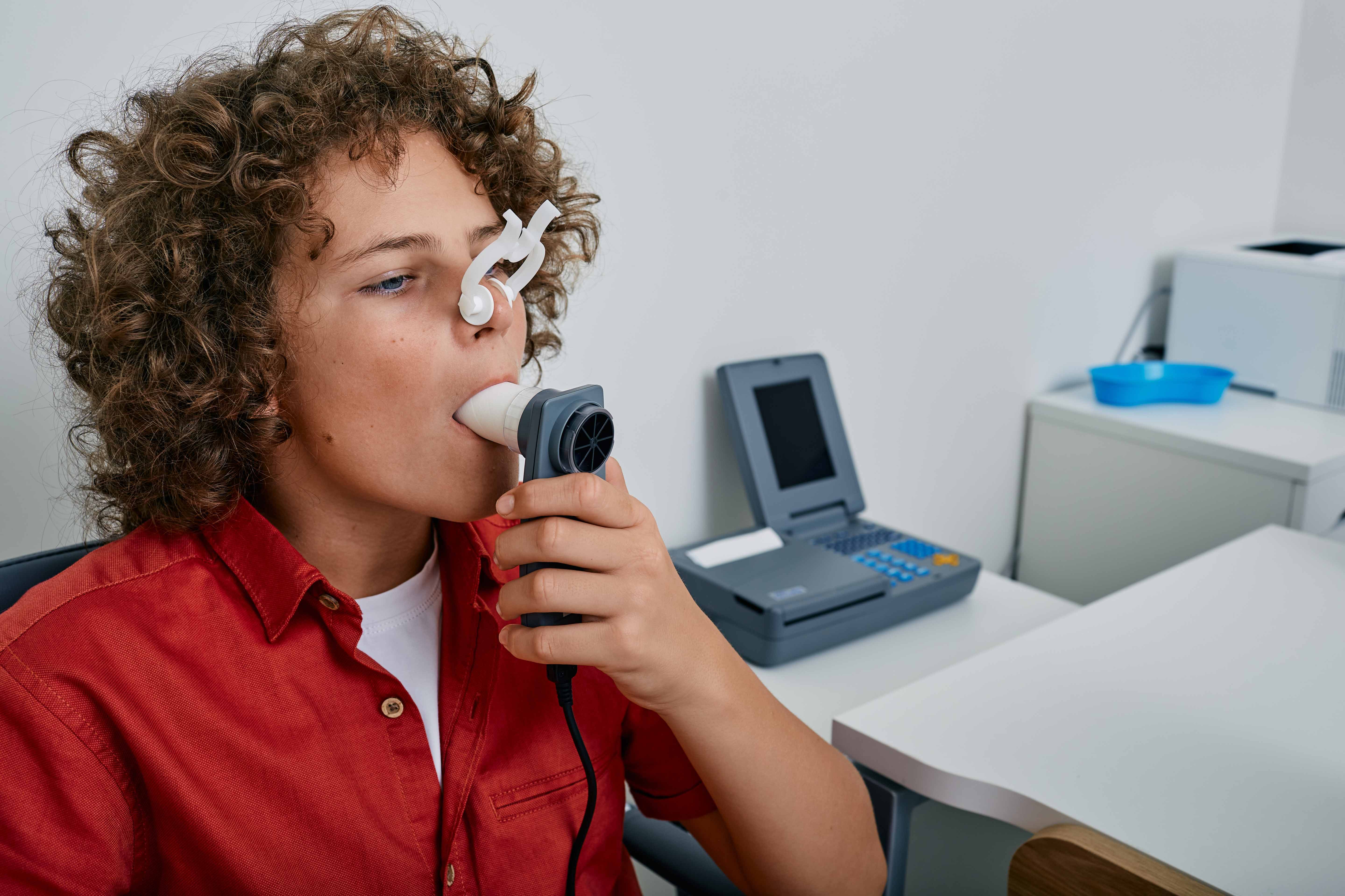 Young person in a medical setting taking a breathing test