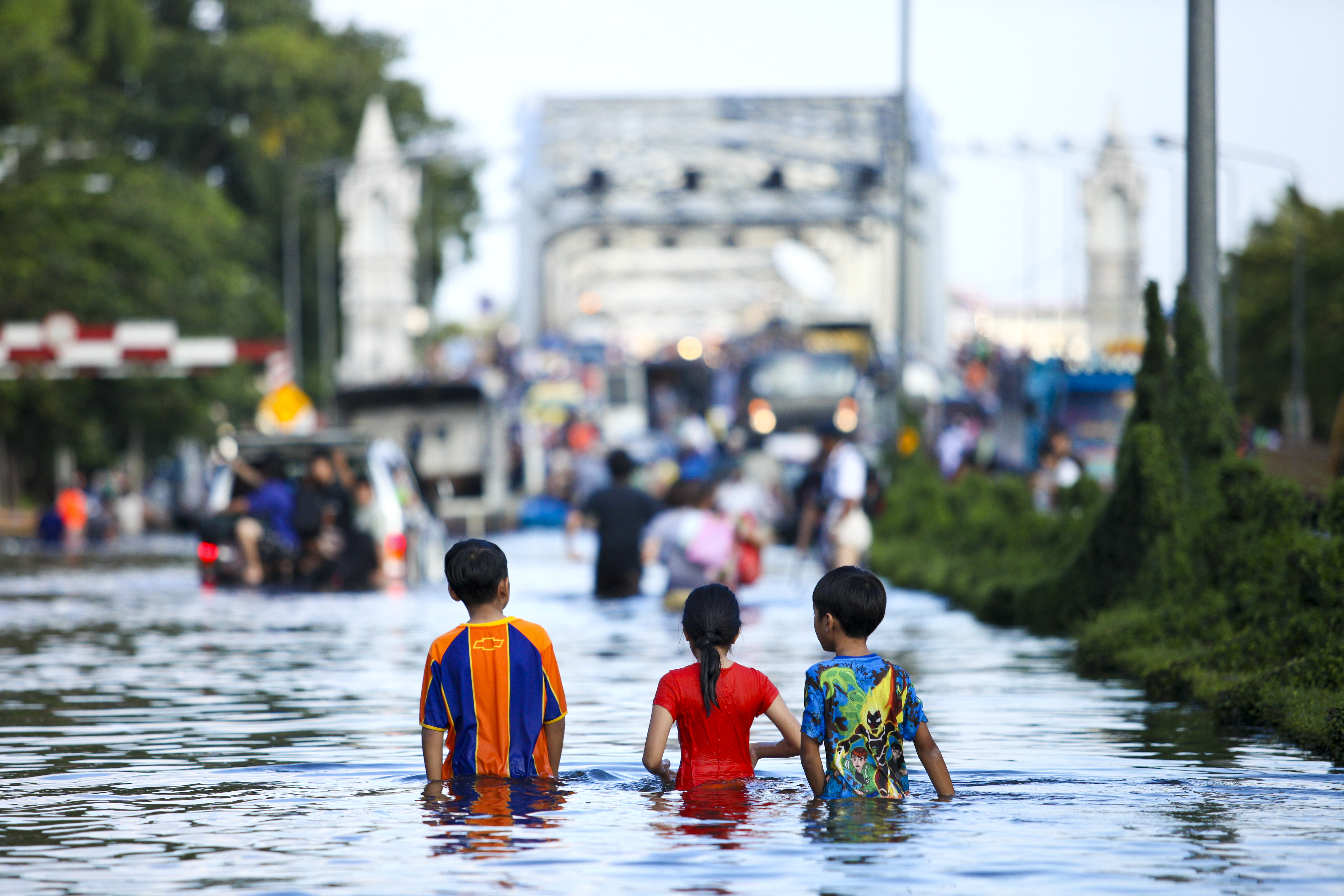Three children standing in a flooded street