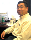 Dr. Xingzhu Liu sitting at his desk.