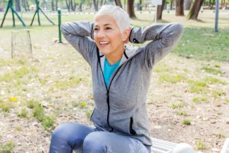 Woman exercises at an outdoor gym. 