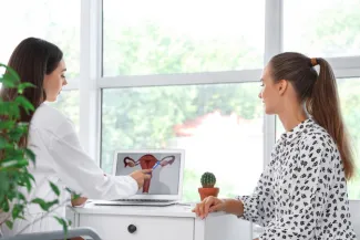Doctor shows patient a diagram of the female reproductive tract.