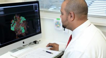 man in white coat analyzing computer screen
