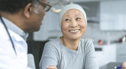 Beautiful Korean woman with cancer smiles at doctor