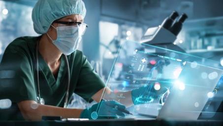 Scientist in PPE reviewing data in a lab