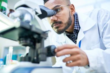 a scientist looking into a microscope