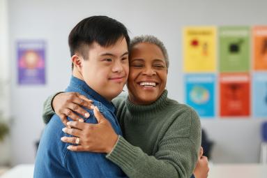 a man with down syndrome hugging his teacher.